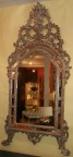 Ornately carved wood framed mirror in a silver finish